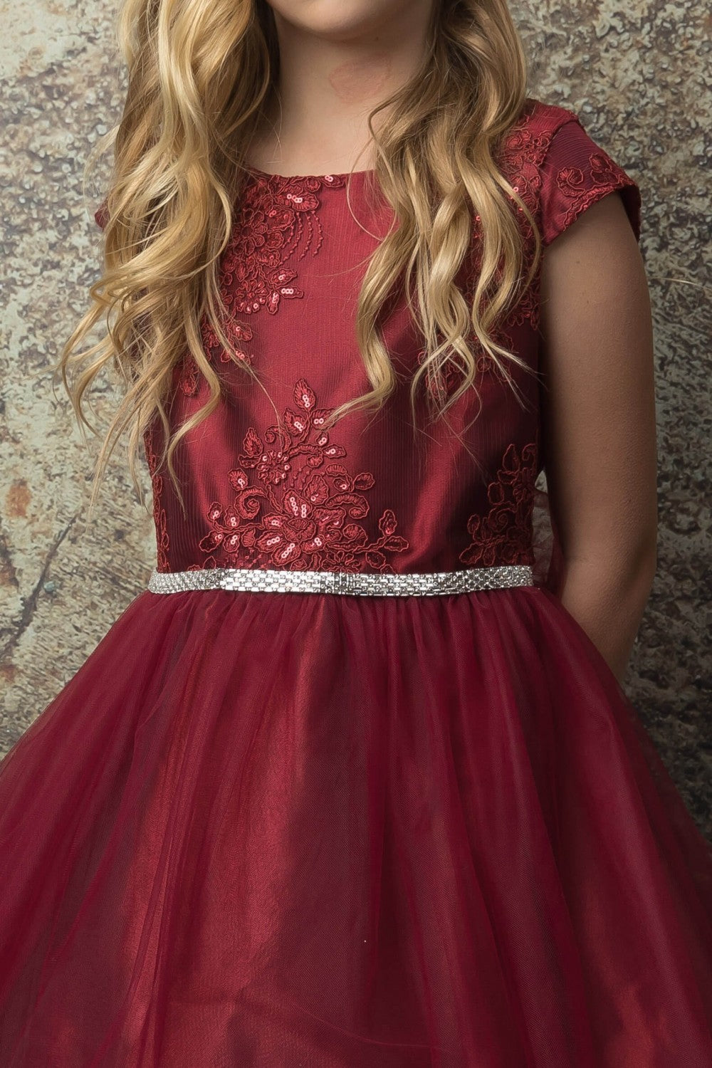Red dress with floral embroidery on a textured background